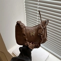 Dark brown pleated underarm bag featuring woven texture and a metal butterfly charm - Tan