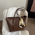 Bruine lederen tote bag met bedrukte zijden sjaal bedel op witte stoel in lifestyle setting - Donkerbruin