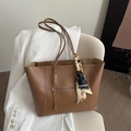Klassieke bruine draagtas met decoratieve zijden sjaal op een beige stoel bij blazer - Tan