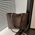 Braune Tote Bag mit Monogramm M Muster und Schultergurten auf der Fensterbank - Braun