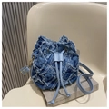Dettaglio borsa a secchiello in denim trapuntato con bordi sfrangiati e coulisse - Blu