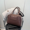 Borsa tote in pelle marrone con doppi manici esposta su una sedia in pelle nera - Marrone