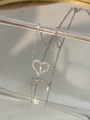 Dettaglio del ciondolo a cuore in argento con pavé di zirconi e riflesso specchiato nitido - Oro Bianco