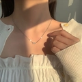Dettaglio della collana infinity in argento S925 su modella con luce morbida - Platino (Melting Heart)