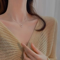 Close-up of a 925 sterling silver star ring pendant necklace worn on a warm sweater - Star Circle Necklace - Platinum
