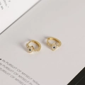 Detailed close-up of S925 silver evil eye huggie earrings with blue stones and gold plating - Evil Eye Earrings - Gold Color