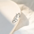 Macro shot of S925 silver leaf ring with sparkling zircons on a white ceramic edge - White Gold