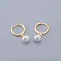 Detalle de elegantes pendientes de aro dorados con colgantes de perlas blancas - Pendientes de Aro de Perlas / Dorado