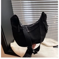 Dettaglio della borsa a mezzaluna in velluto nero con tracolla larga e zip intrecciata - Nero