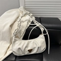 Beige geraffte Cloud-Tasche mit Schleifenakzenten und glänzendem Leder auf dunklem Grund - Weiß