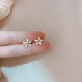 Macro view of white cat eye stone flower earrings with gold bead center detail - Marquise Zirconia Flower