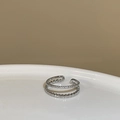 Nahaufnahme eines doppellagigen Silberrings mit Mikro-Zirkonia und Perlenmetall-Struktur - Einstellbar Offen / Weißgold