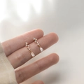Orecchini a goccia in argento S925 dorato con zircone sul dito della modella - Oro