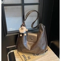 Deep brown large leather hobo bag with plush charm on vintage books background - Brown