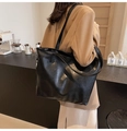 Detail of soft black PU leather tote bag with subtle texture and silver zipper closure - Black