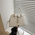 Bolso bowling blanco crema con asas dobles y correa de hombro en un entorno minimalista - Blanco