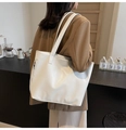 Side view of white faux leather tote bag with subtle texture and silver zipper detail - Off White