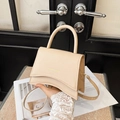 Sac bandoulière abricot chic avec base incurvée et lettrage doré tenu à la main - Khaki