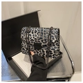 Dettaglio borsa leopardata con catena in metallo scuro e chiusura a scudo - Nero