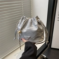 Silver wrinkled bucket bag with gold chain strap and fashion logo in handheld view - Silver