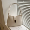 Chic cream leather shoulder bag with decorative knotted strap and gold buckle detail - White