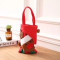 Close-up of a festive Christmas reindeer gift bag made of red felt with a holiday hat decoration - Elk Style