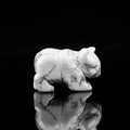 Howlite stone bear carving figurine with natural grey veins on a black background - Howlite