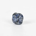 Miniature blue sodalite planet stone carving with natural black speckles on white surface - Blue Sodalite