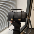 Cylindrical black crossbody bag with embossed floral texture and gold twist lock - Black