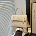 Chic cream crossbody handbag with gold hardware and wide shoulder strap shown in a modern setting - Off White