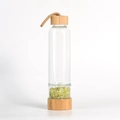Bamboo lid glass bottle with protective sleeve and green peridot crystal chips - Citrine