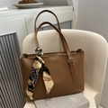 Brown leather tote bag with silk scarf accessory and gold brand plaque on front - Tan
