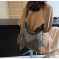 Side view of dark grey matte leather tote bag with silver zippers on a female model - Dark Brown