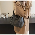 Detail view of charcoal grey hobo bag with vintage matte finish and functional side pocket - Black