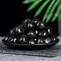 Polished black obsidian tumbled stones for healing and home decor in a dark plate - Obsidian (Large)