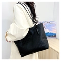Detailed close-up of large black tote bag with embossed star pattern and leather texture - Black