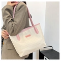 Detail of cream tote bag with pink trim and FASHION & BAGS label on model shoulder - Pink