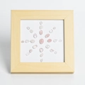 Marco de madera con cuarzo rosa y cristal en un patrón solar radial - Cuarzo rosa