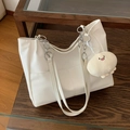 White large capacity tote bag with silver chain strap and cute plush charm on wood table - Off White