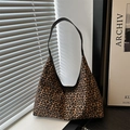 Vintage Hobo-Schultertasche mit Leopardenmuster und schwarzem Gurt in stilvollem Ambiente - Dunkelbraun