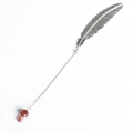 Vintage metal feather bookmark with a red crystal mushroom pendant on white background - Strawberry Quartz