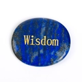 Lapis Lazuli duimsteen ovaal met gouden Wisdom gravure op een witte achtergrond - Lapis Lazuli: Wijsheid