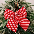 Rot-weiße gestreifte Weihnachtsschleife mit Pfefferminz-Detail auf verschneitem Tannenzweig - Pfefferminz Schwamm Schleife Rot Weiß Fein Gestreift