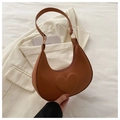 Close-up of brown crescent underarm bag with embossed heart detail and gold ring hardware - Brown