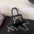 Mini black leather handbag featuring a sparkling rhinestone bow and silver chain strap - Black