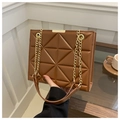 Brown quilted tote bag with triangle pattern and golden chain strap held by hand - Brown