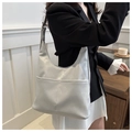 Detalle de bolso de hombro gris claro con dos bolsillos frontales en una modelo con blazer - Gris