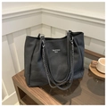 Gros plan d'un sac cabas en toile noir avec chaîne en métal sur une table basse - Noir
