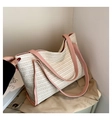 Straw woven tote bag in cream white with pink handles shown over a beige trench coat - Pink