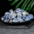 Polished natural blue Sodalite tumbled stones displayed in a black tray for healing - Blue And White Dots 1-2cm 100g